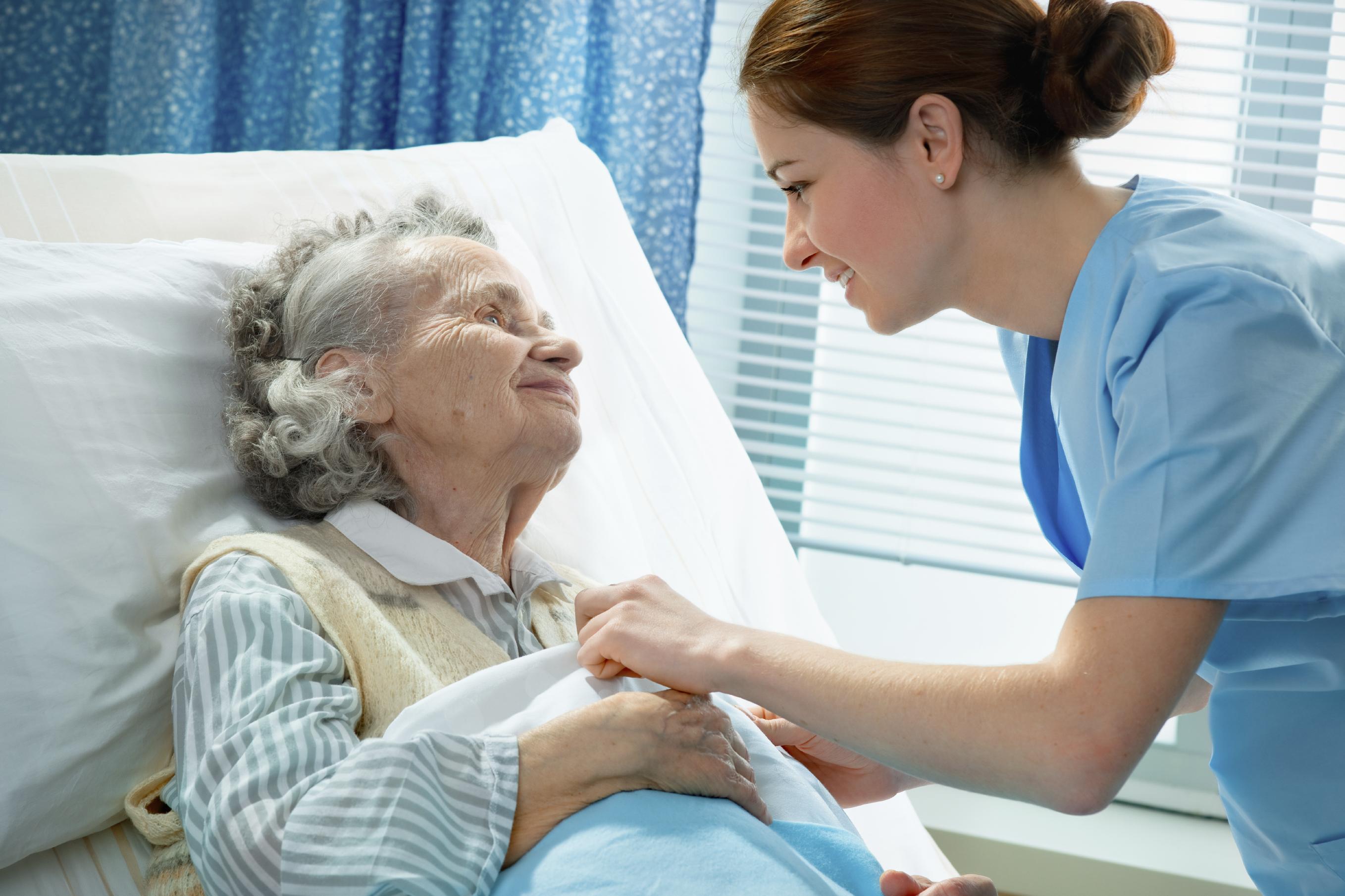 护士在病床旁照顾一位老年病人.